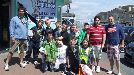 Youth scout group posing outside Tramore Surf Shop with gear after a surf session.